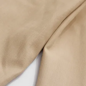 Dettaglio ravvicinato del tessuto beige di alta qualità per completo da donna.