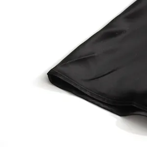 Macro detail of high-quality black satin fabric and stitching on a women's suit