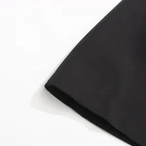 Gros plan d'une manche de blazer noir pour femme montrant la texture du tissu fini