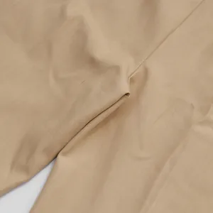 Dettaglio ravvicinato del tessuto beige e della cucitura di pantaloni a gamba larga