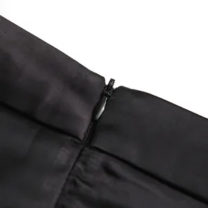 Close-up detail of a black high-waisted skirt featuring a hidden invisible zipper.