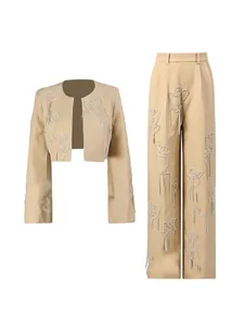 Completo due pezzi con top corto decorato e pantaloni a gamba larga beige