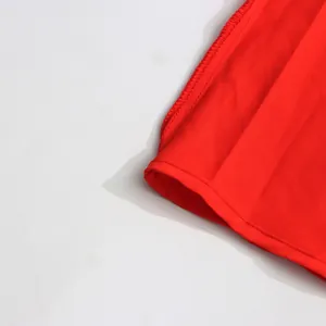 Κοντινό πλάνο του κόκκινου στριφώματος της φούστας με λεπτές ραφές και ύφασμα ποιότητας.