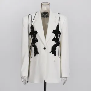Macro detail view of black sequined butterfly embroidery on white elegant blazer jacket