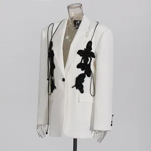 Close-up detail of high-end white blazer featuring black sequined butterfly decorations