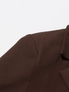 Close-up detail of dark brown British style blazer shoulder seam and lapel texture.