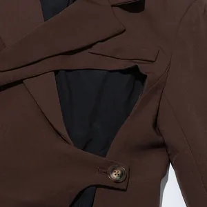 Macro shot of the irregular hollow-out design and lapel on a stylish brown suit jacket.