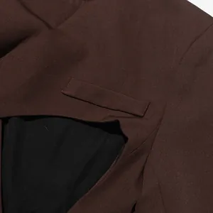 Detail of brown blazer featuring unique cutout design and premium textured fabric.