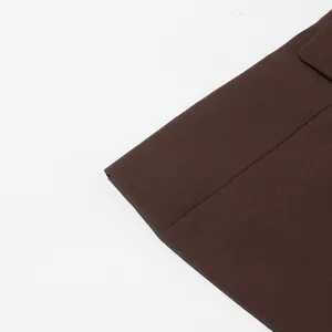 Detailed close-up showing the premium fabric and clean hemline of a dark brown blazer jacket