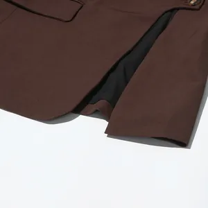 Close-up of irregular hollow design and black lining on brown British style blazer
