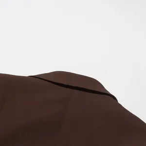Close-up of the elegant brown blazer's notched lapel and high-quality fabric texture