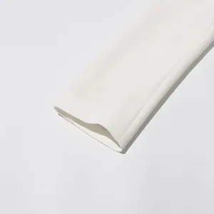 Close-up detail of a white blazer sleeve showing smooth fabric texture and clean hemline