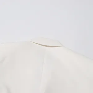 Close-up of the white blazer collar showing high-quality stitching and fabric texture.