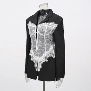 Close-up detail of a black blazer featuring an intricate white lace corset panel