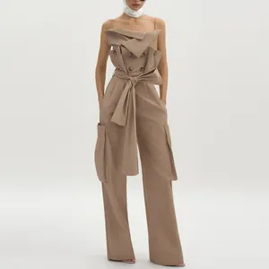 Front detail of khaki wide-leg jumpsuit featuring double-breasted buttons and waist tie