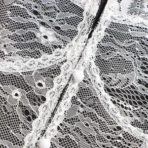 Macro view of elegant white lace patchwork details and white buttons on black blazer