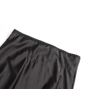 Close-up of elegant black satin skirt waistband featuring delicate scalloped lace trim