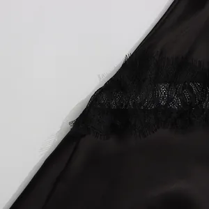 Detailed close-up showing the delicate black eyelash lace trim on a satin midi skirt