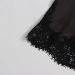 Detailed macro shot of black satin midi skirt featuring delicate floral eyelash lace trim