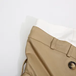 Detalle de cerca de un vestido caqui de dos piezas con botón y textura