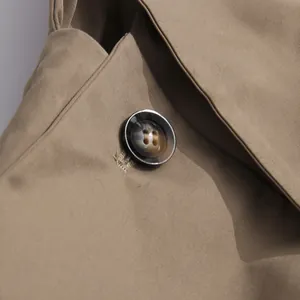 Macro view of marble-patterned button on high-quality khaki jumpsuit fabric detail
