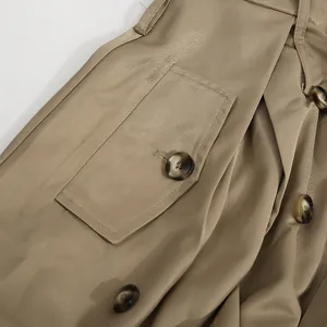 Primer plano de un vestido caqui con botones de mármol y textura de tejido de sarga.