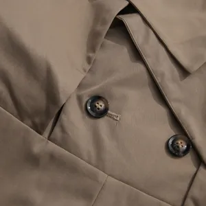 Detailed macro view of marble textured buttons on elegant khaki French style jumpsuit