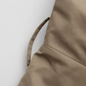 Close-up detail of khaki French style jumpsuit strap showing fine fabric texture and stitching