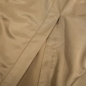 Detalle macro de la tela de sarga caqui y costuras en un elegante vestido de dos piezas