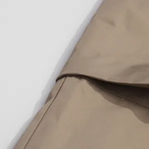 Detailed close-up of khaki jumpsuit fabric showing texture and high-quality stitching.