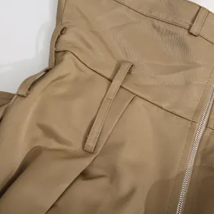 Detalle en primer plano de la cintura del vestido caqui con trabillas y cremallera lateral