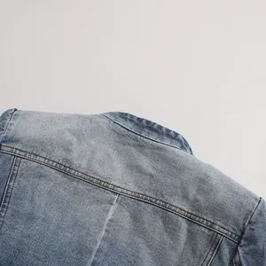 Close-up detail of back collar and stitching on a distressed blue denim blazer jacket