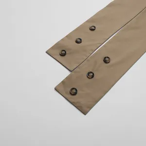 Detailed view of tortoiseshell buttons on elegant khaki jumpsuit fabric texture