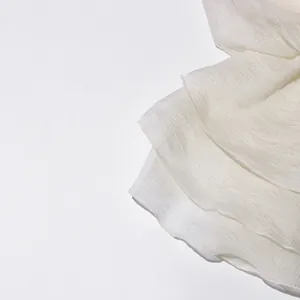Close-up detail van witte chiffon stof met delicate ruches en een zeer fijne textuur