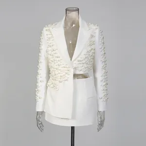Dettaglio di un set blazer bianco con perle di lusso e un profondo design con scollo a V