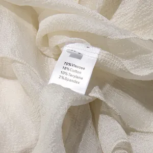 Detailweergave van het kledinglabel met de materiaalsamenstelling van de chiffon jurk
