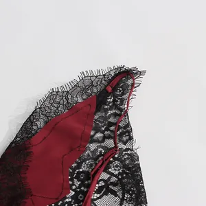 Close-up detail of delicate black eyelash lace spliced with burgundy silk fabric texture