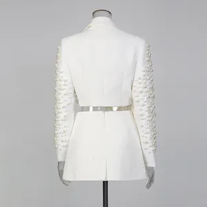 Vista posteriore dettagliata di elegante set blazer e gonna bianco con maniche con perline