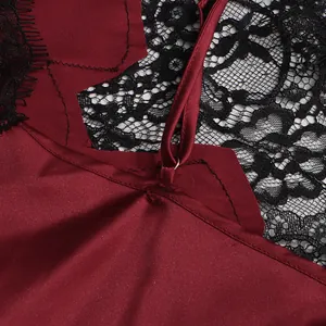 Close-up detail showing the burgundy satin fabric and black floral lace on this camisole top.