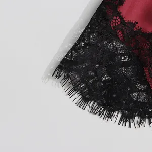 Macro view showing the intricate black lace trim and burgundy silk fabric of a camisole top
