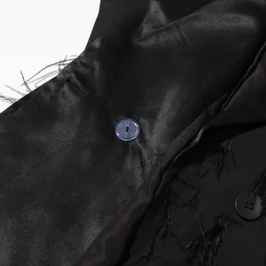 Macro view of black satin blazer dress detailing ostrich feather trim and unique buttons