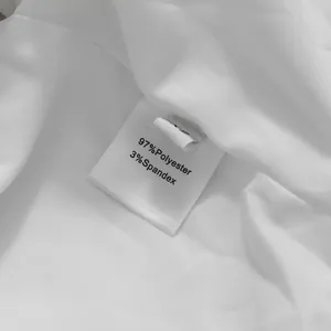 Dettaglio etichetta lavaggio abbigliamento bianco: 97% poliestere e 3% elastan