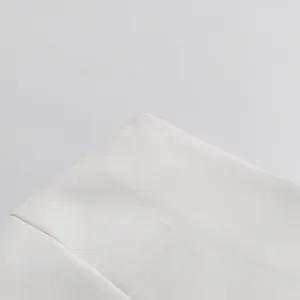 Dettaglio macro del tessuto bianco per tailleur con trama fine e cuciture pulite.