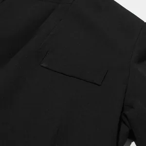 Close-up detail showing the refined pocket flap and texture of a black blazer dress