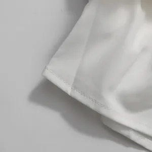 Dettaglio macro ravvicinato della cucitura e dell'orlo in tessuto bianco di una gonna
