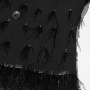 Detailed close-up of a black blazer dress featuring luxury ostrich feather patchwork