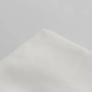 Primo piano di alta qualità del tessuto bianco premium su un completo blazer da donna su misura.