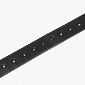 Close-up detail of a premium black leather belt with metal eyelets for women's dress.