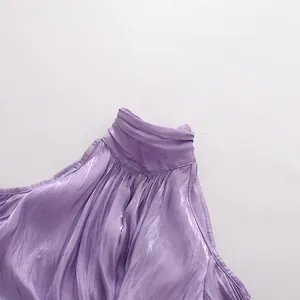 Detailansicht einer eleganten lila Satinbluse mit Stehkragen und Plisseetextur.