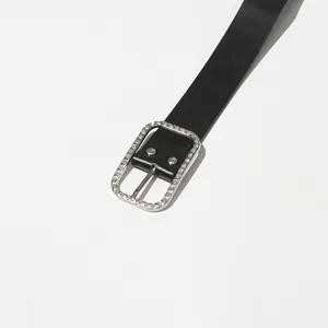 Detailed view of an elegant black leather belt with a rhinestone-studded silver buckle